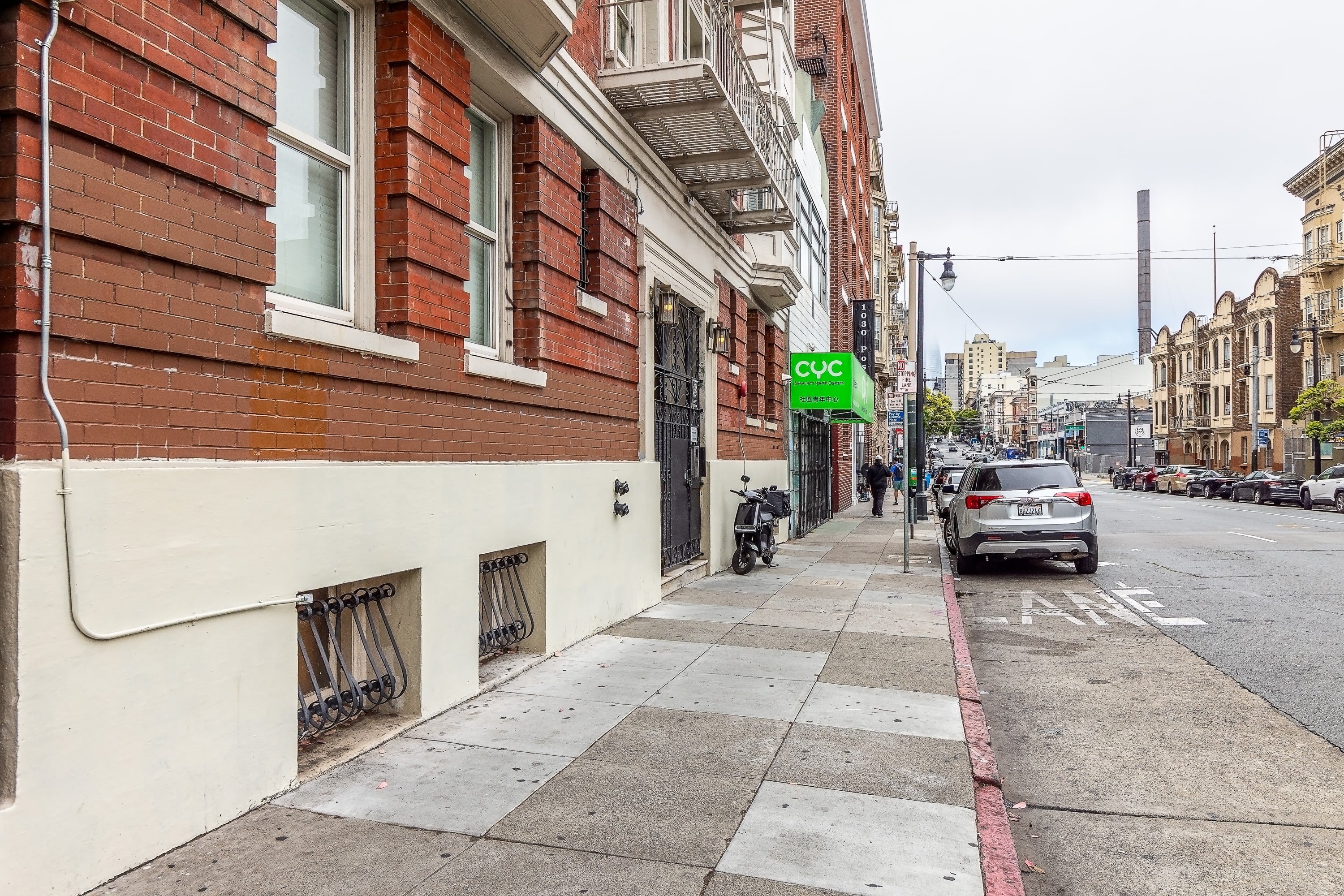 A street view with a car parked on the side of the road.